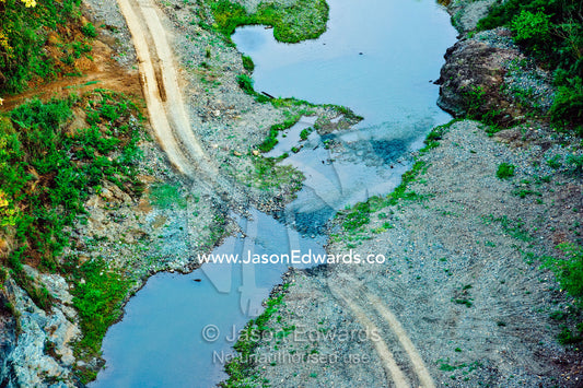 A road between farming villages passes through a small river. Viti Levu Island, Pacific Ocean, Fiji Islands.