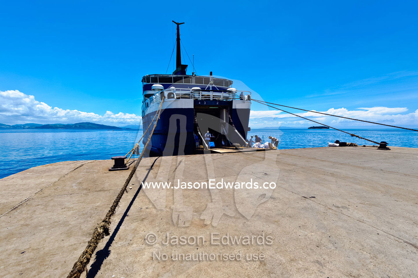 An island cargo ferry tied at a jetty waiting to be loaded with goods. Taveuni Island, Somosomo Strait, Pacific Ocean, Fiji Islands.