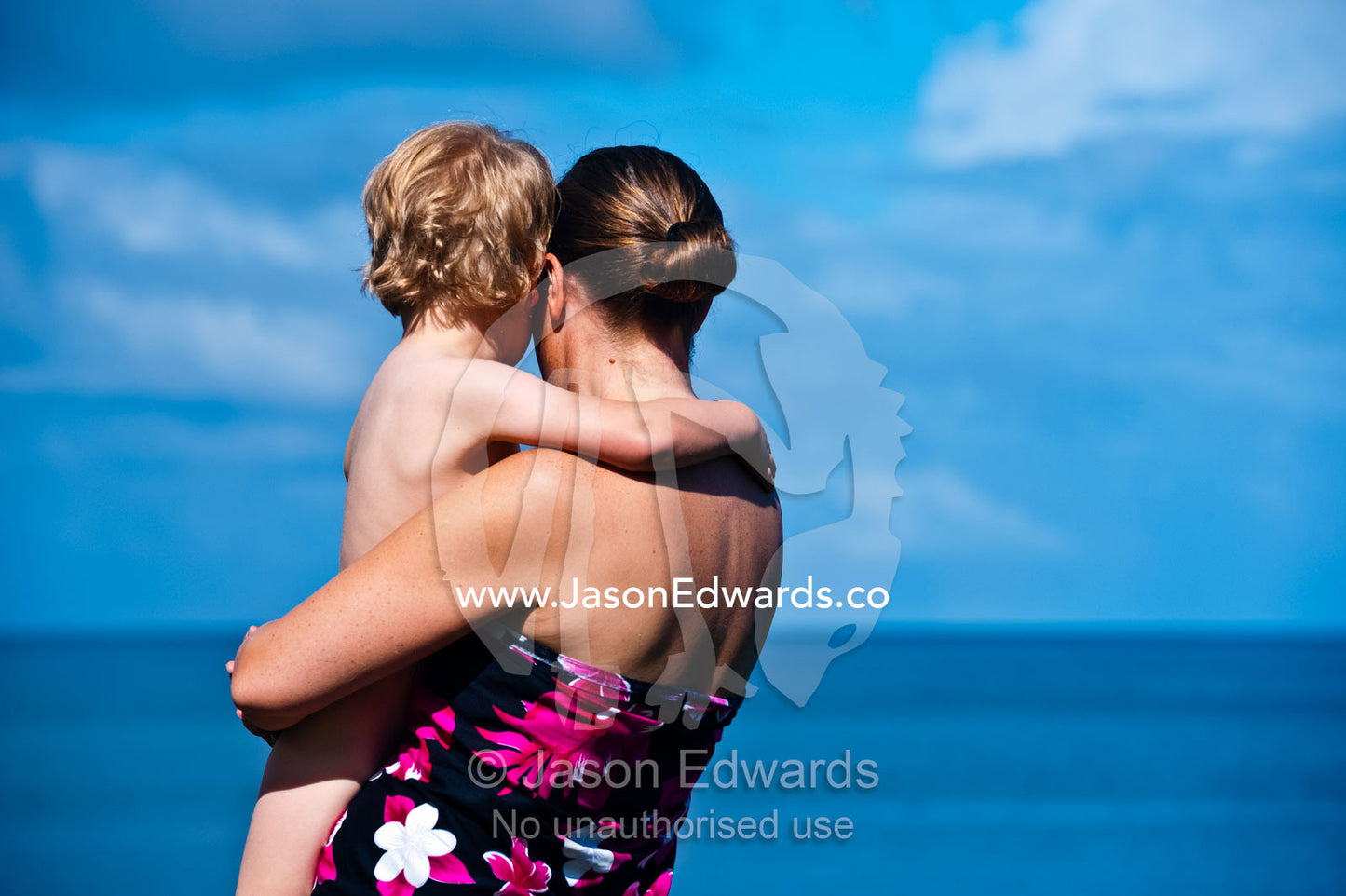 A mother and son gaze out to the horizon from a tropical island. Taveuni Island, Somosomo Strait, Pacific Ocean, Fiji Islands.