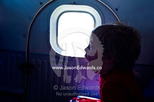 A boy yawns on a light plane travelling between tropical islands. Viti Levu Island, Pacific Ocean, Fiji Islands.