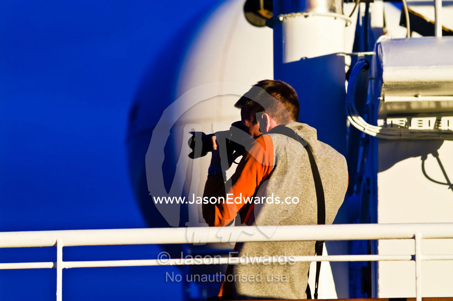 A tourist photographs from the bridge of a ship heading to Antarctica. The Beagle Channel, Tierra del Fuego Archipelago, Strait of Magellan, Ushuaia, Tierra del Fuego Province, Patagonia, Argentina.