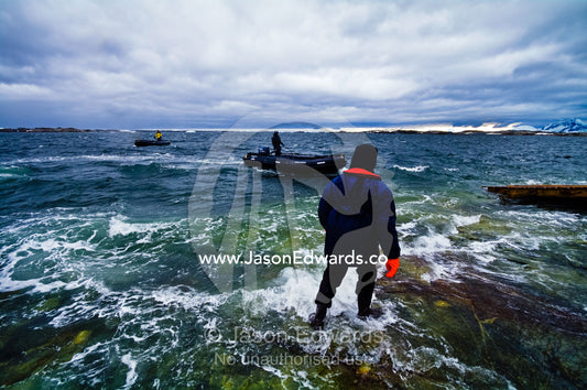 Ship's crew in insulated waterproof suits about to load zodiac boats. Vernadsky Antarctic Research Base, Galindez Island, Argentine Islands, Faraday Islands, Antarctic Peninsula, Antarctica.