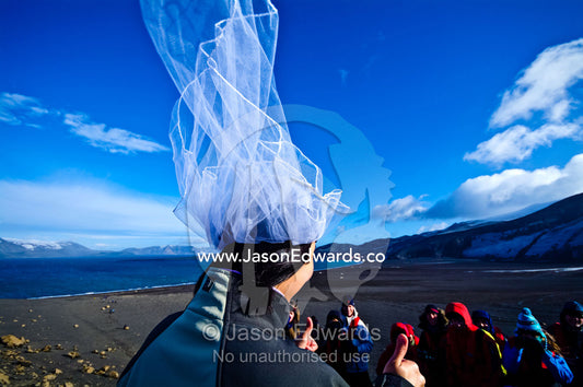 A newly wed bride gives the thumbs-up after her wedding in Antarctica. Neptune's Window, Whalers Bay, Antarctic Historic Site, Port Foster, Deception Island, South Shetland Islands, Antarctic Peninsula, Antarctica.