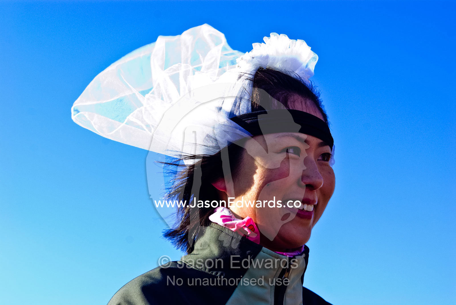 A smiling bride in her wedding veil flapping in the Antarctic wind. Neptune's Window, Whalers Bay, Antarctic Historic Site, Port Foster, Deception Island, South Shetland Islands, Antarctic Peninsula, Antarctica.