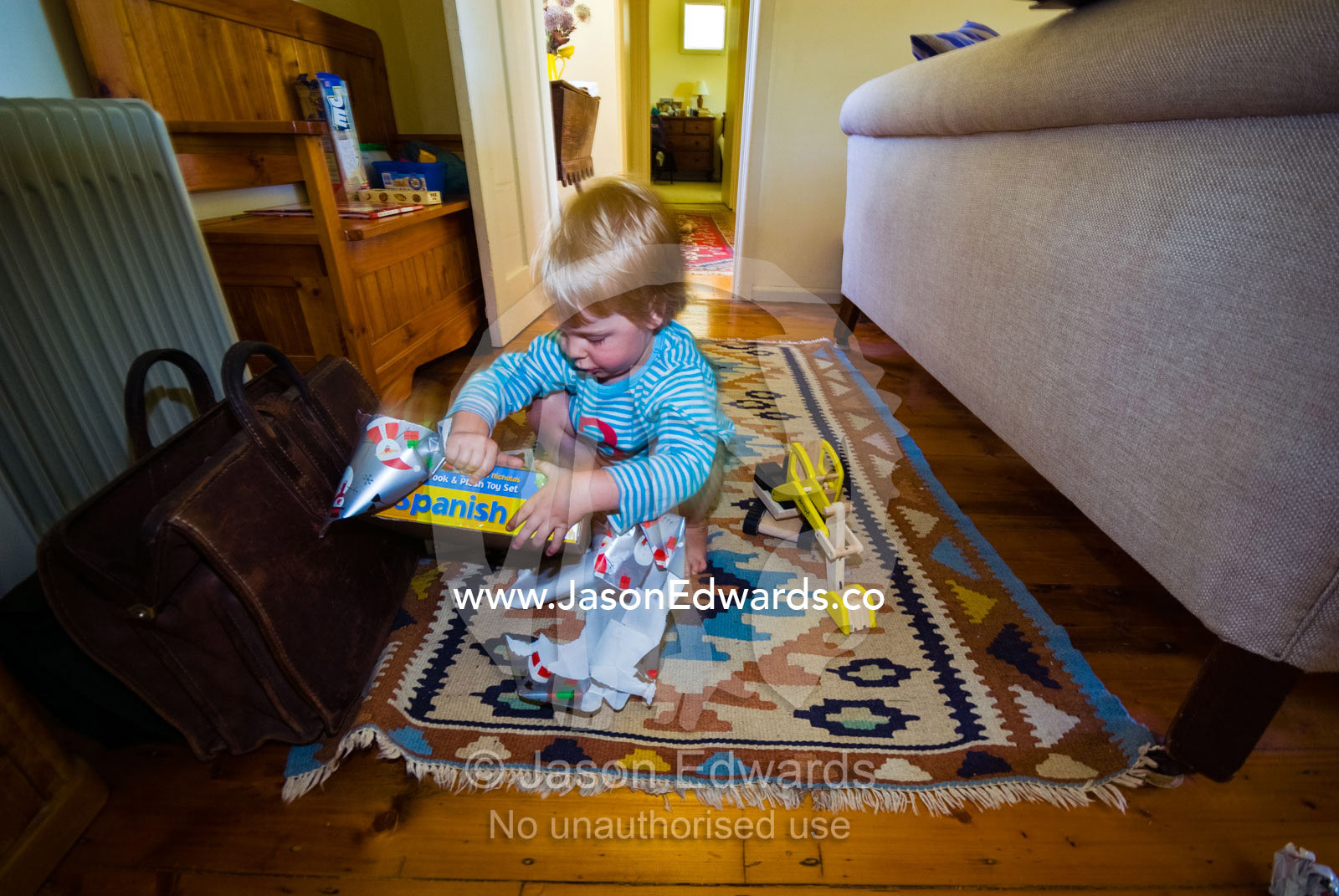 A boy opens a Spanish language game he received as a Christmas gift. Castlemaine, Victoria, Australia.