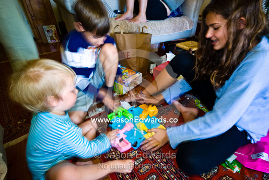 Three cousins play a game on Christmas morning. Castlemaine, Victoria, Australia.