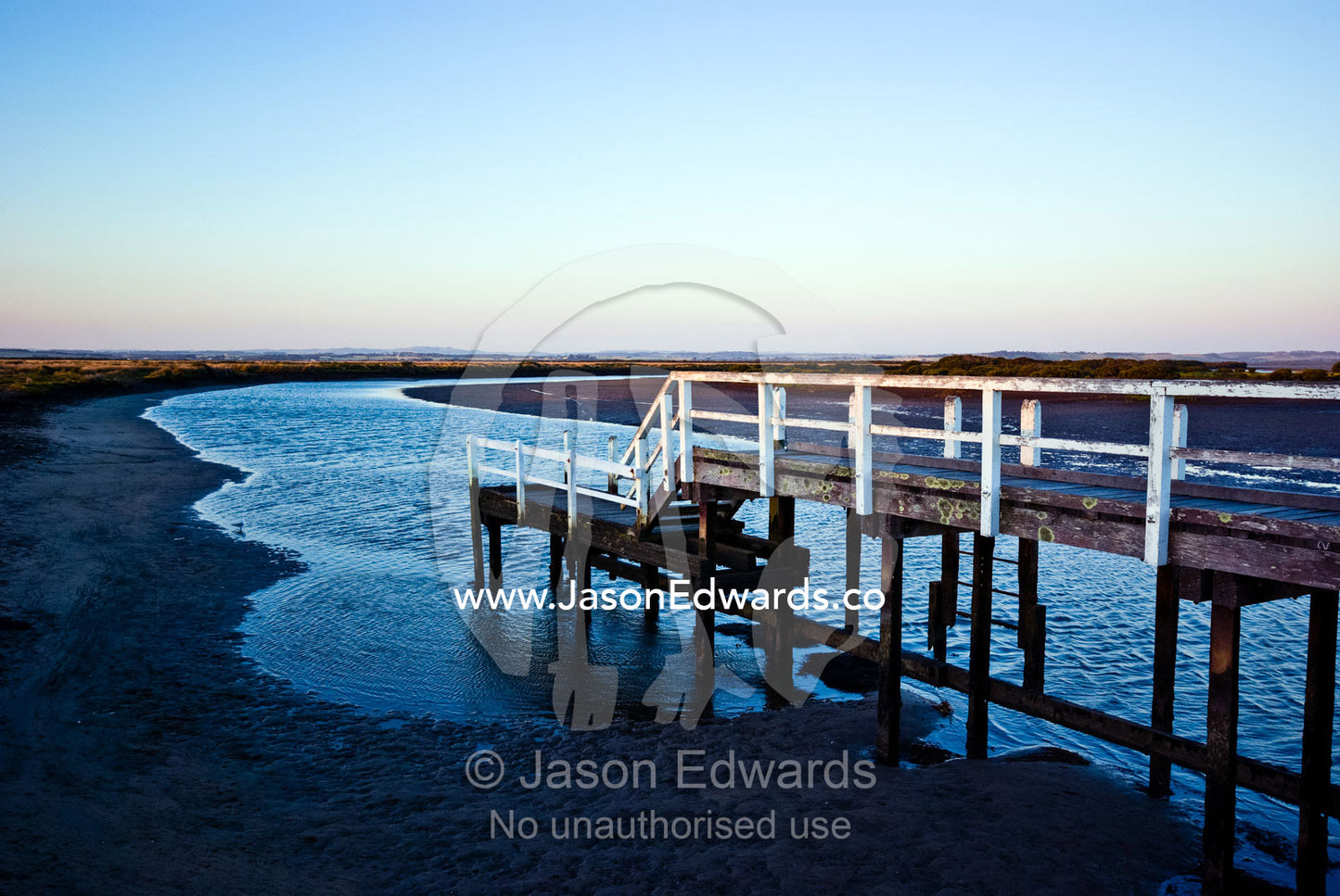Twilight descends over jetty above a wide tidal river and mud flat. Anderson's Inlet, Venus Bay, South Gippsland, Victoria, Australia.