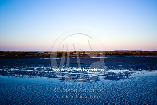 Moonrise at twilight over a wide, tranquil tidal river and mud flat. Anderson's Inlet, Venus Bay, South Gippsland, Victoria, Australia.