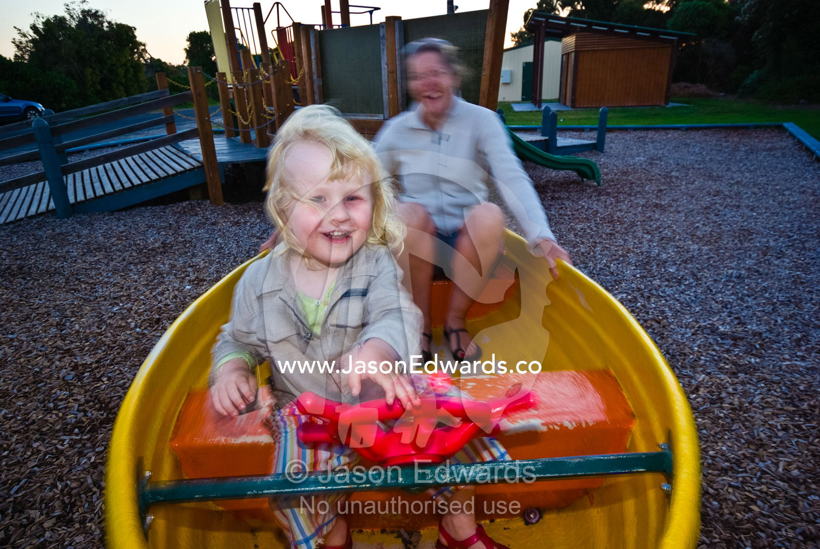 A young boy plays in a rocking boat in a children's playground. Anderson's Inlet, Venus Bay, South Gippsland, Victoria, Australia.