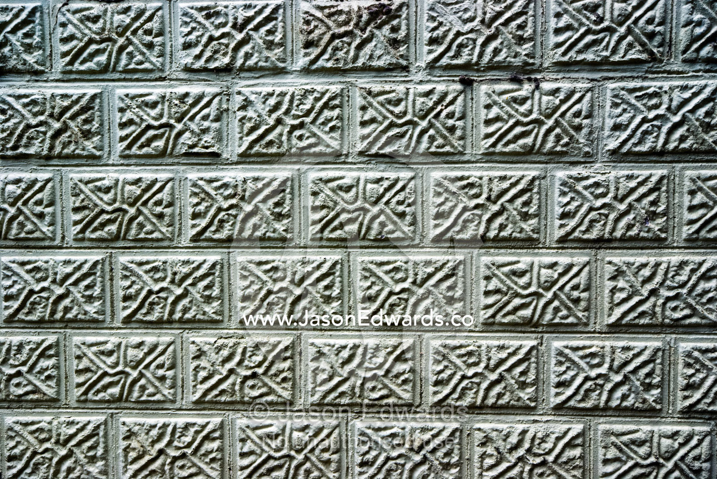 The textured surface of a brick retaining wall at a sandy beach. Rye Beach, Melbourne, Victoria, Australia.