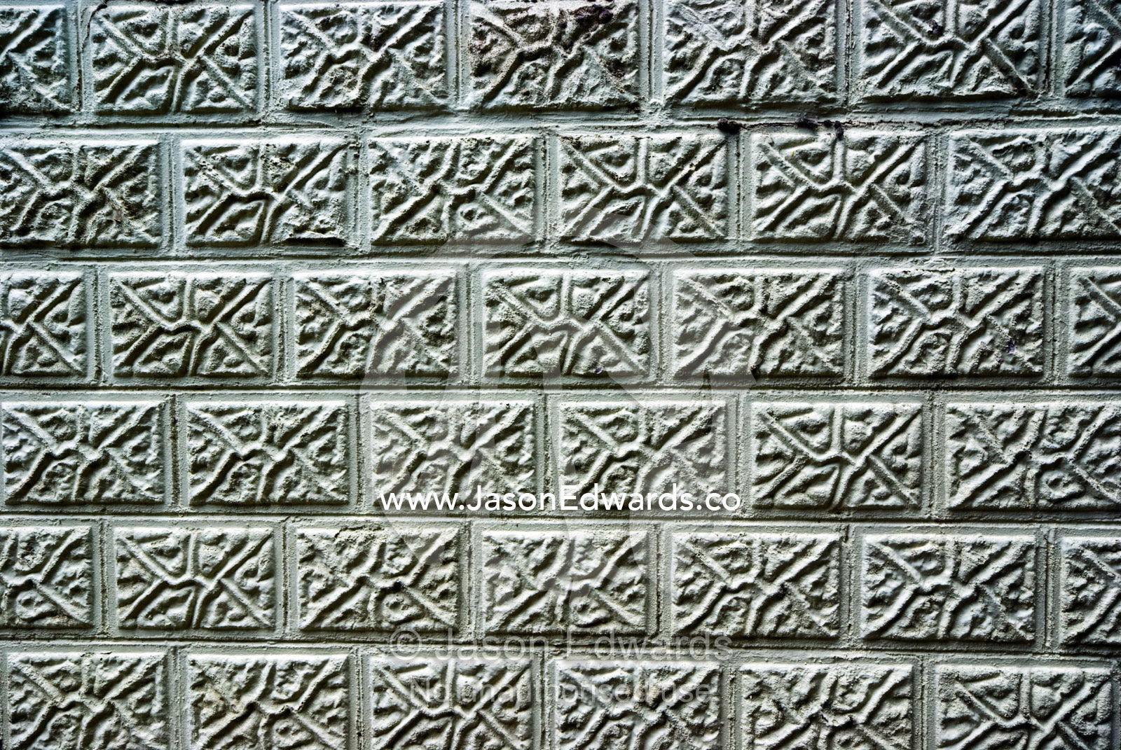 The textured surface of a brick retaining wall at a sandy beach. Rye Beach, Melbourne, Victoria, Australia.