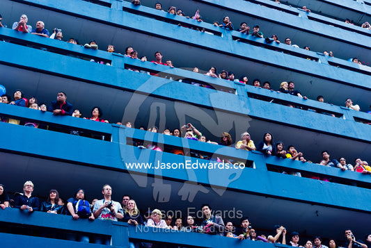 Crowds gather balconies on a high-rise car park to watch a parade. Melbourne, Victoria, Australia.