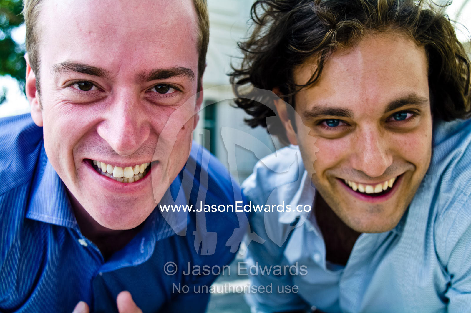 Two well-dressed young and attractive male friends laugh and have fun. Carlton, Melbourne, Victoria, Australia.