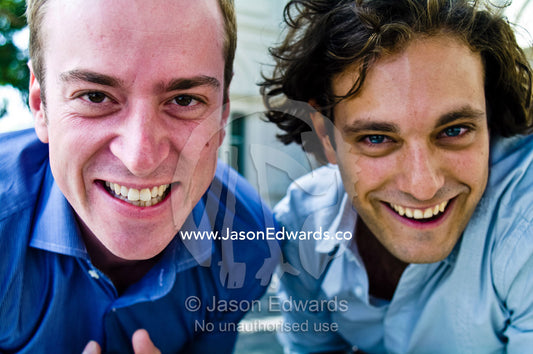 Two well-dressed young and attractive male friends laugh and have fun. Carlton, Melbourne, Victoria, Australia.