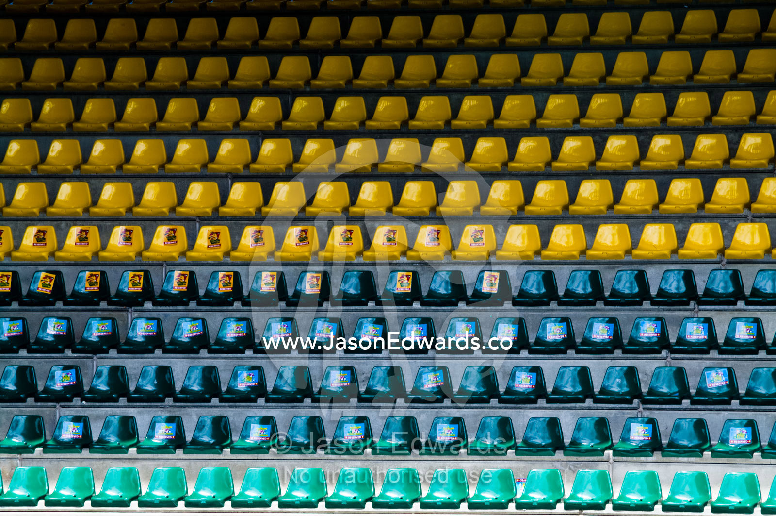 Empty rows of green and yellow plastic chairs in a stadium balcony. Crocoseum, Australia Zoo, Beerwah, Queensland, Australia.