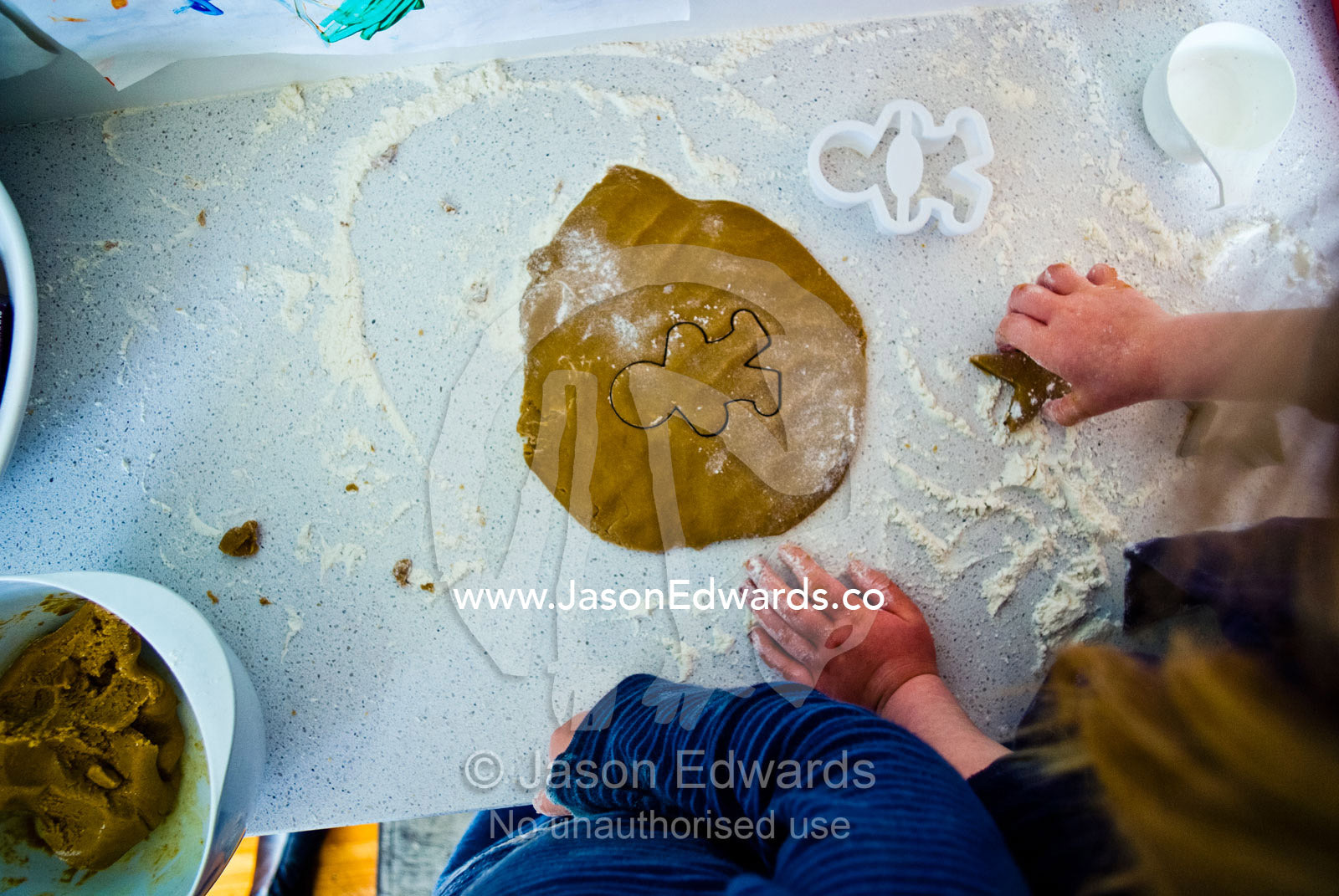 Children use flour and a cookie cutter to bake gingerbread men. Carlton North, Melbourne, Victoria, Australia.