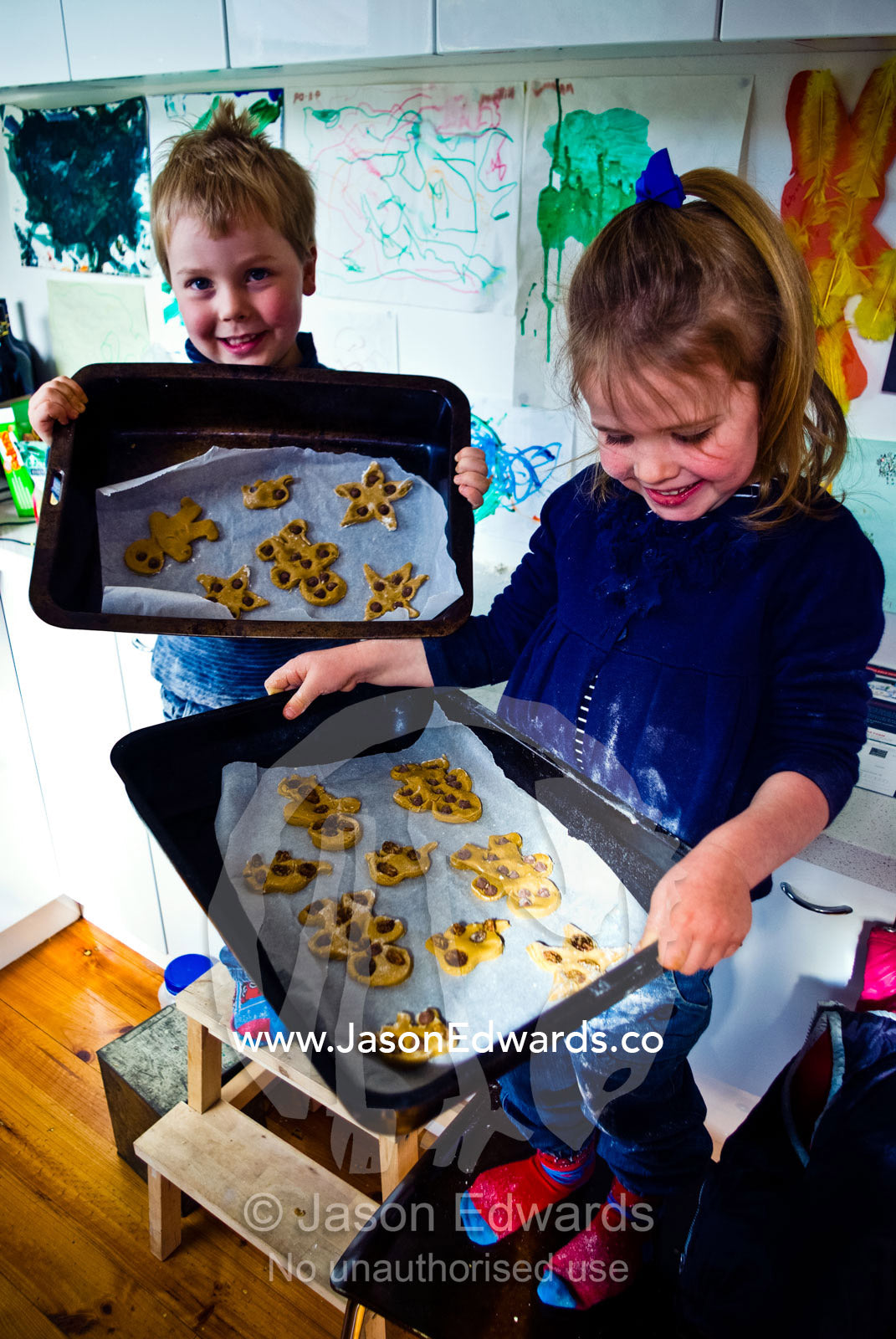 Children proudly display their gingerbread men and baking skills. Carlton North, Melbourne, Victoria, Australia.
