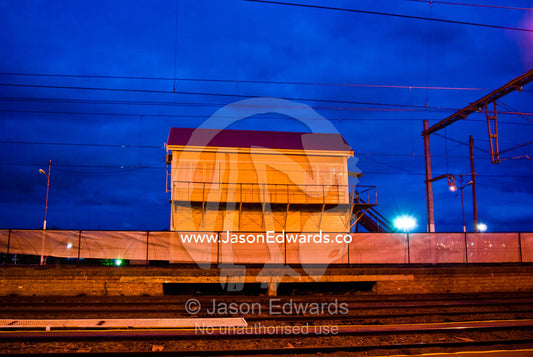 An empty railway station and tracks under flood lights late at night. Flemington, Victoria, Australia.