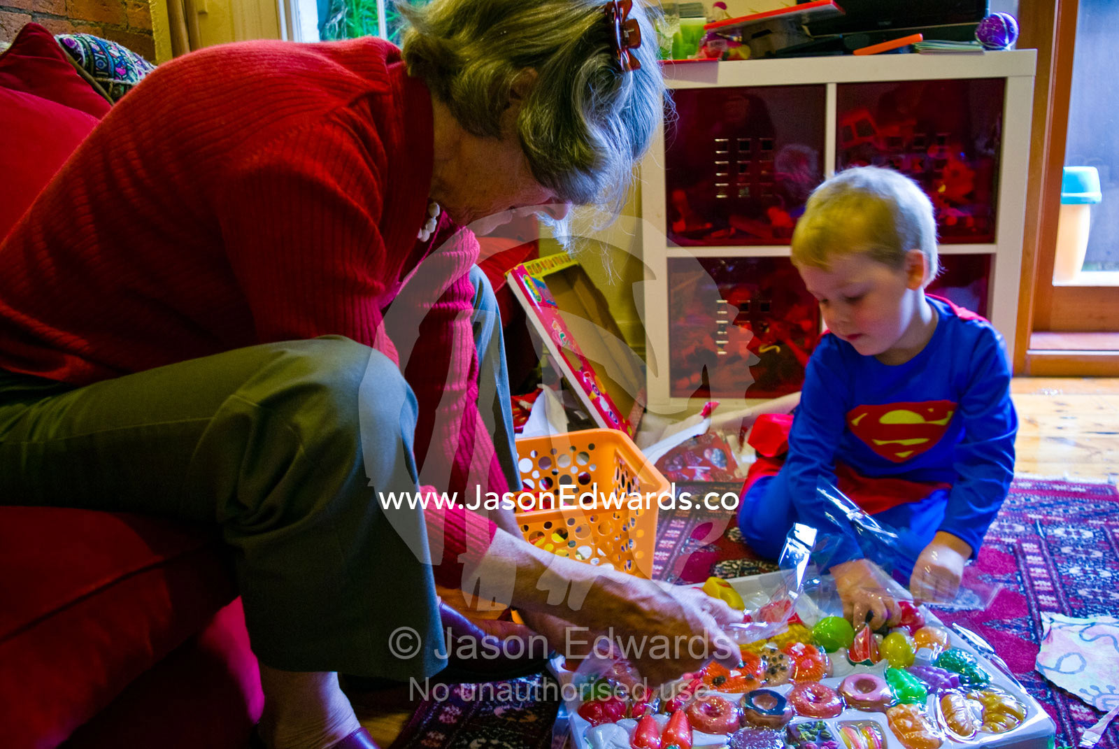 A young boy and his Grandmother open a Christmas gift of toy foods. Carlton North, Melbourne, Victoria, Australia.