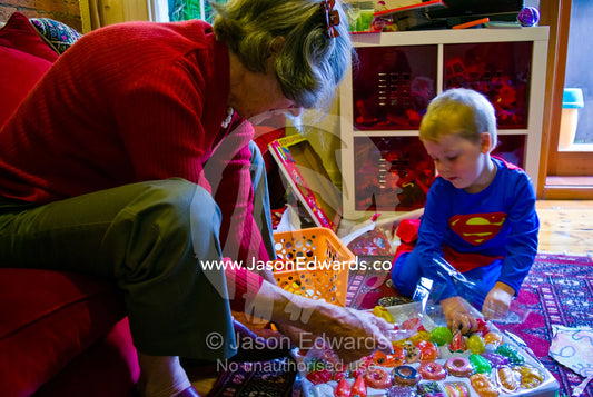 A young boy and his Grandmother open a Christmas gift of toy foods. Carlton North, Melbourne, Victoria, Australia.