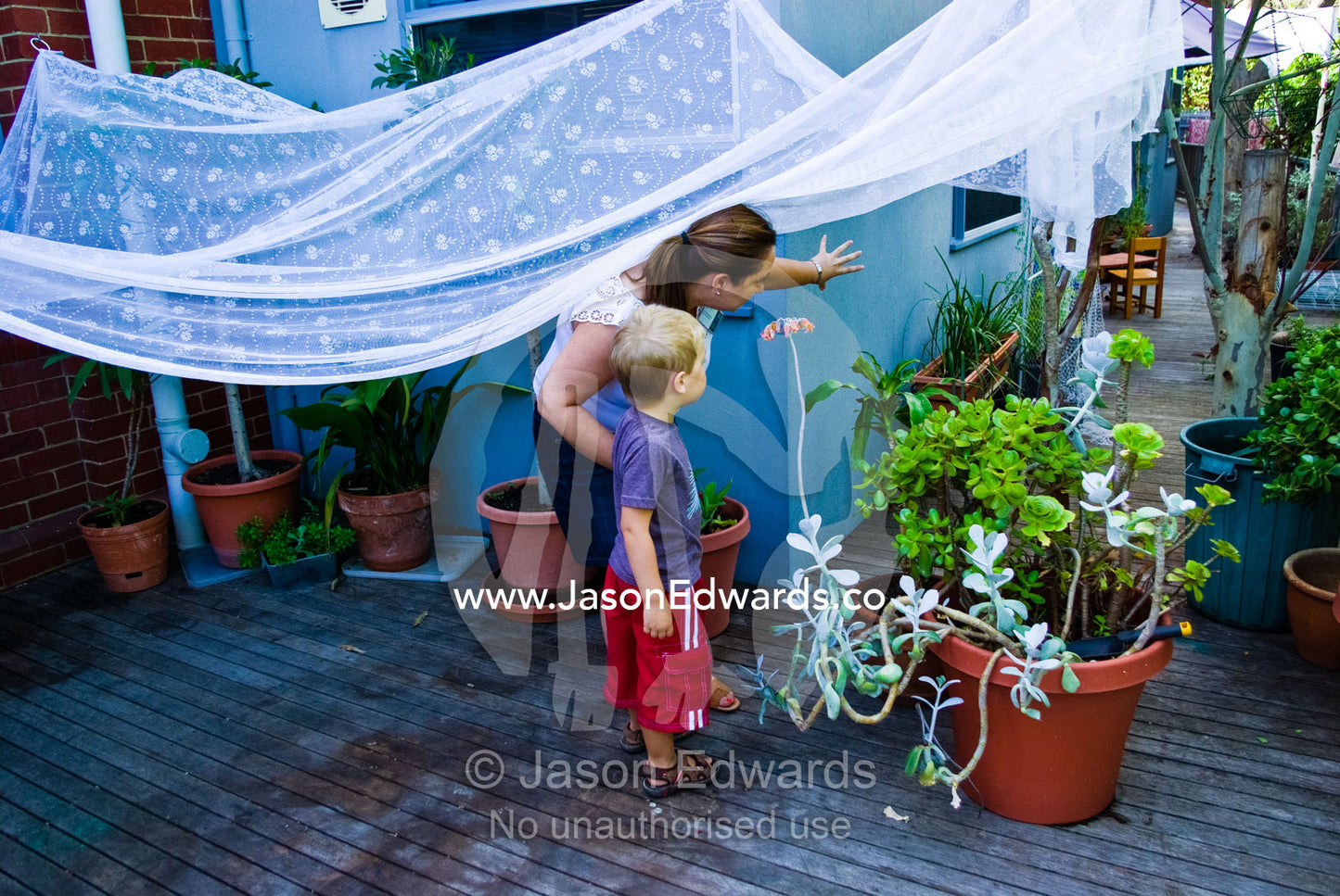 A teacher shows a boy around his new kindergarden on his first day. University of Melbourne Early Learning Centre, Abbotsford, Collingwood, Melbourne, Victoria, Australia.