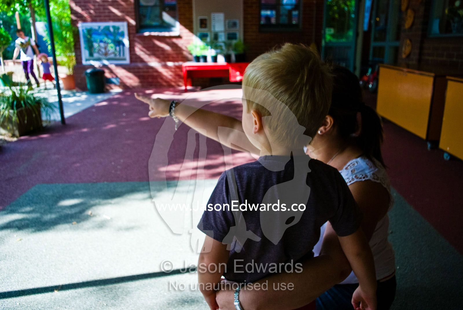 A teacher shows a boy around his new kindergarden on his first day. University of Melbourne Early Learning Centre, Abbotsford, Collingwood, Melbourne, Victoria, Australia.