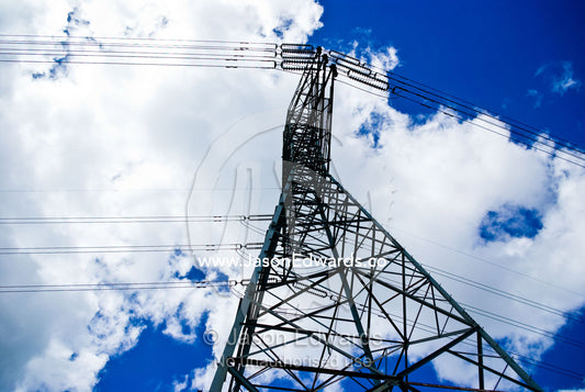 A steel high voltage electricity tower and cables rising into the sky. Gardener's Creek Trail, Malvern East, Melbourne, Victoria, Australia.
