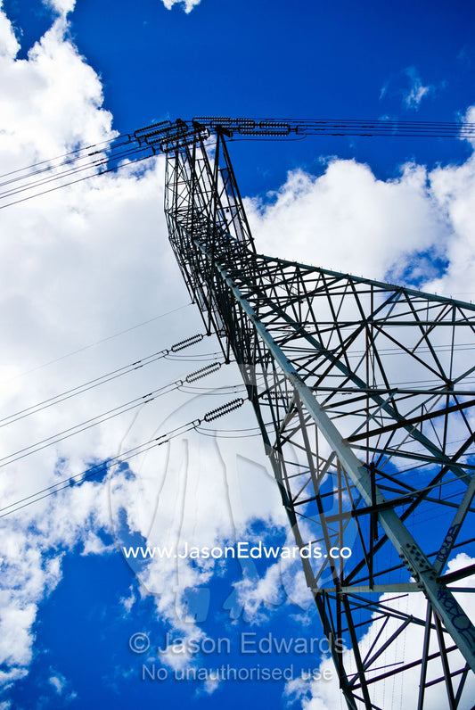 A steel high voltage electricity tower and cables rising into the sky. Gardener's Creek Trail, Malvern East, Melbourne, Victoria, Australia.