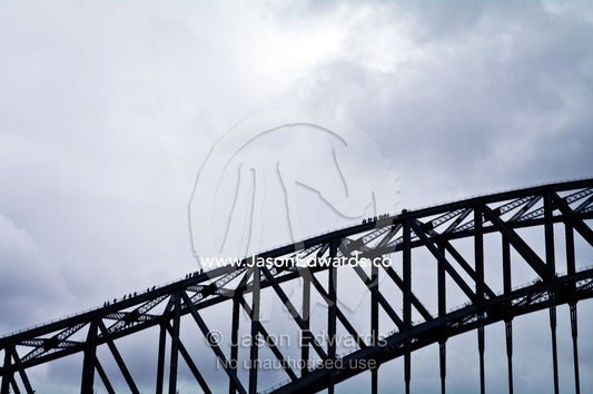 Huge steel girders dwarf tourists climbing the Sydney Harbour Bridge. Sydney Harbour, Sydney Cove, Warrane, Port Jackson, Circular Quay, Sydney, New South Wales, Australia.