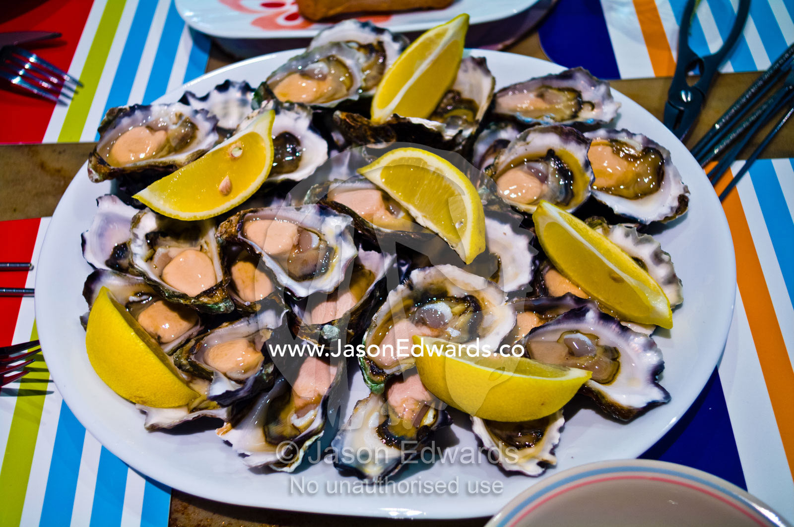 A plate piled high with fresh oysters and lemon for a Chinese lunch. Campsie, Syndey, New South Wales, Australia.