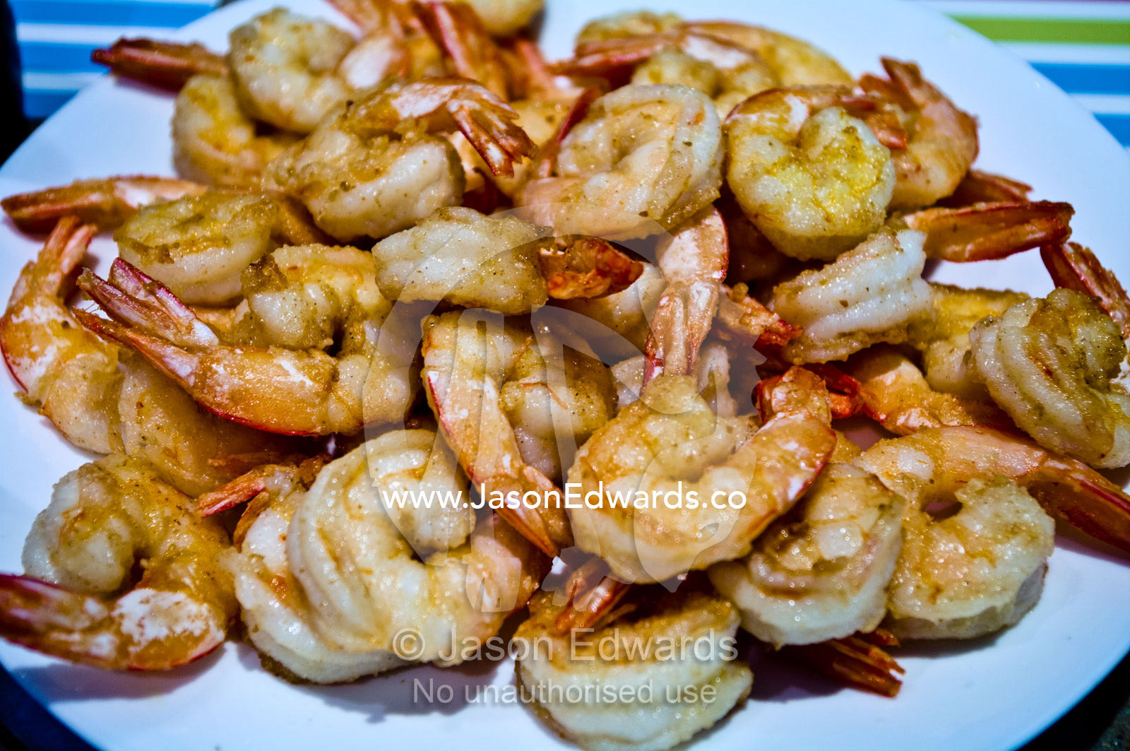 A plate piled high with fresh prawn grilled on the barbecue for lunch. Campsie, Syndey, New South Wales, Australia.