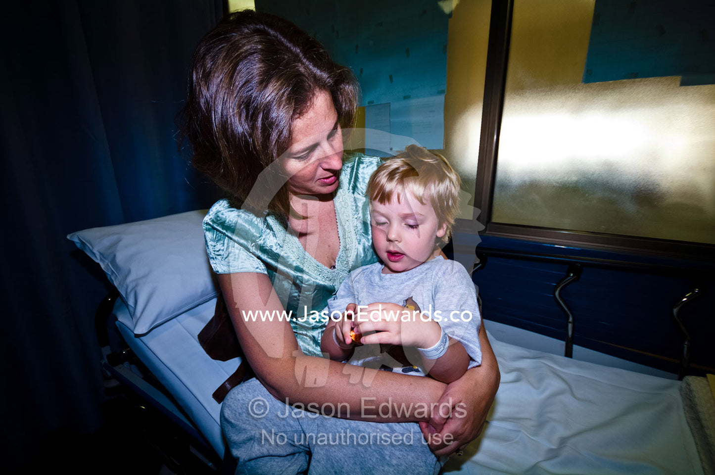A mother comforts her son before he undergoes ear surgery in hospital. Epworth Freemasons Hospital, East Melbourne, Victoria, Australia.