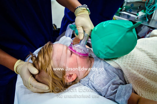 A boy inhales anaesthetic in an operating room for ear surgery. Epworth Freemasons Hospital, East Melbourne, Victoria, Australia.