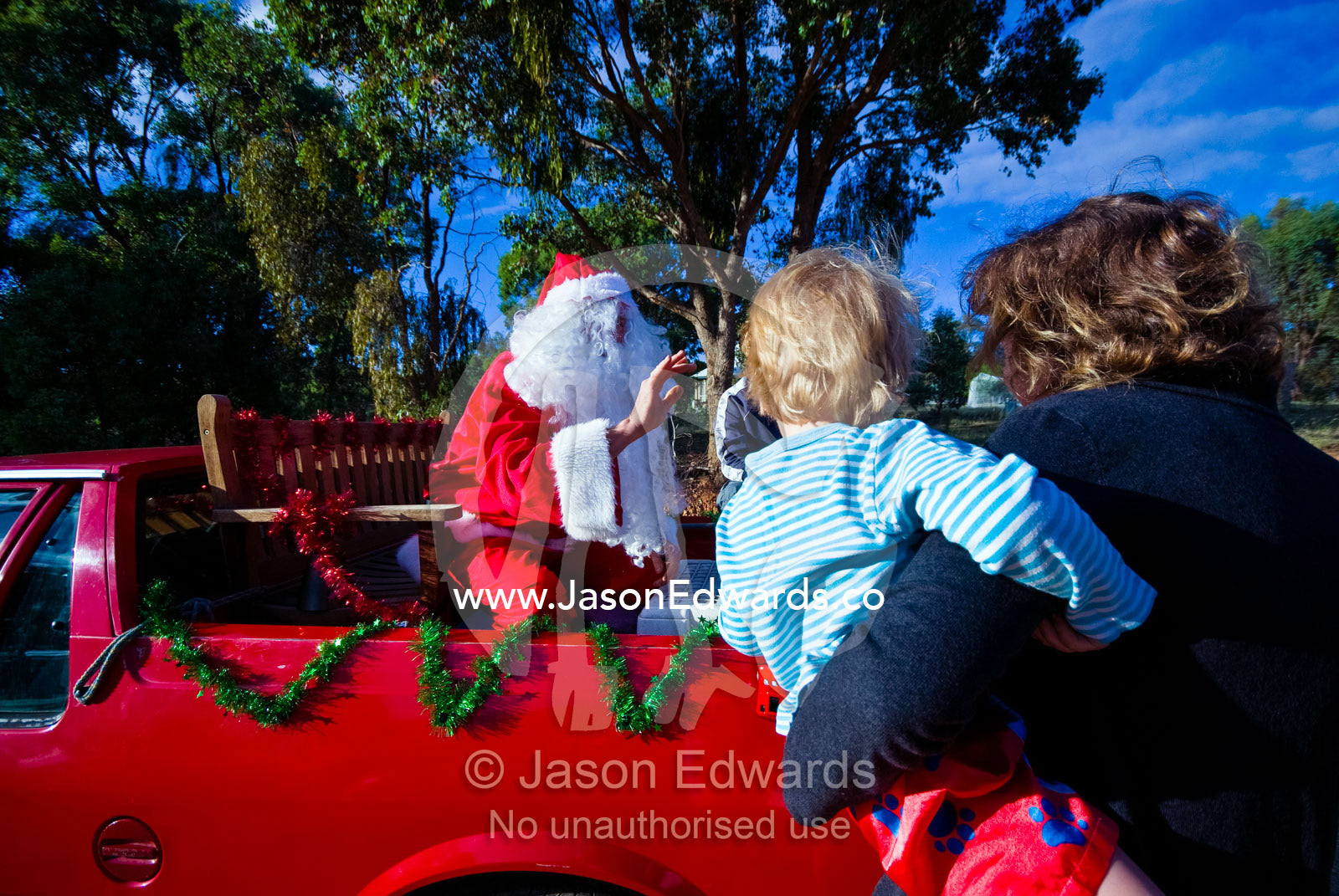 Father Christmas in a country town meets a small boy on Christmas Day. Castlemaine, Victoria, Australia.
