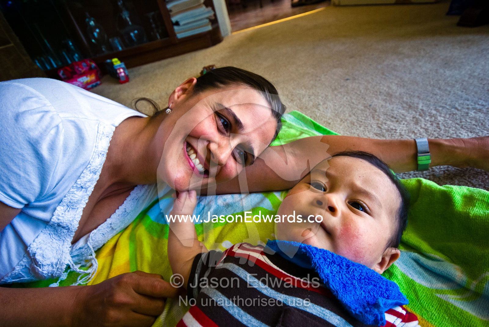 A mother plays with her baby on the living room floor of their house. Rye, Melbourne, Victoria, Australia.