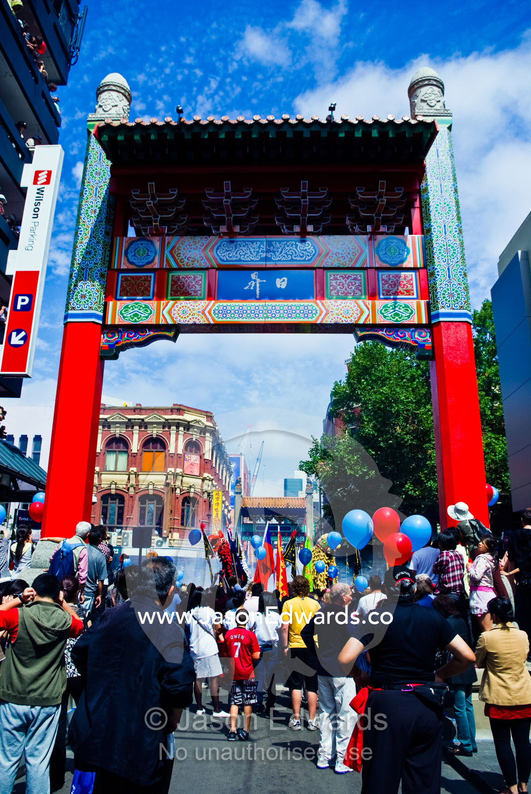 Crowds gather to celebrate Chinese New Year with fireworks and flags. Chinatown, Melbourne, Victoria, Australia.