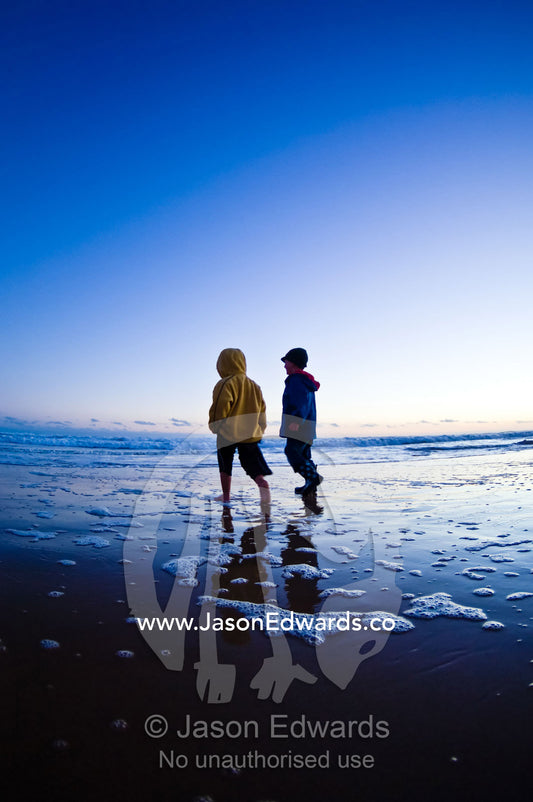 Two young friends explore a remote stretch of beach at twilight. Venus Bay, Cape Liptrap Coastal Park, Bass Strait, South Gippsland, Victoria, Australia.