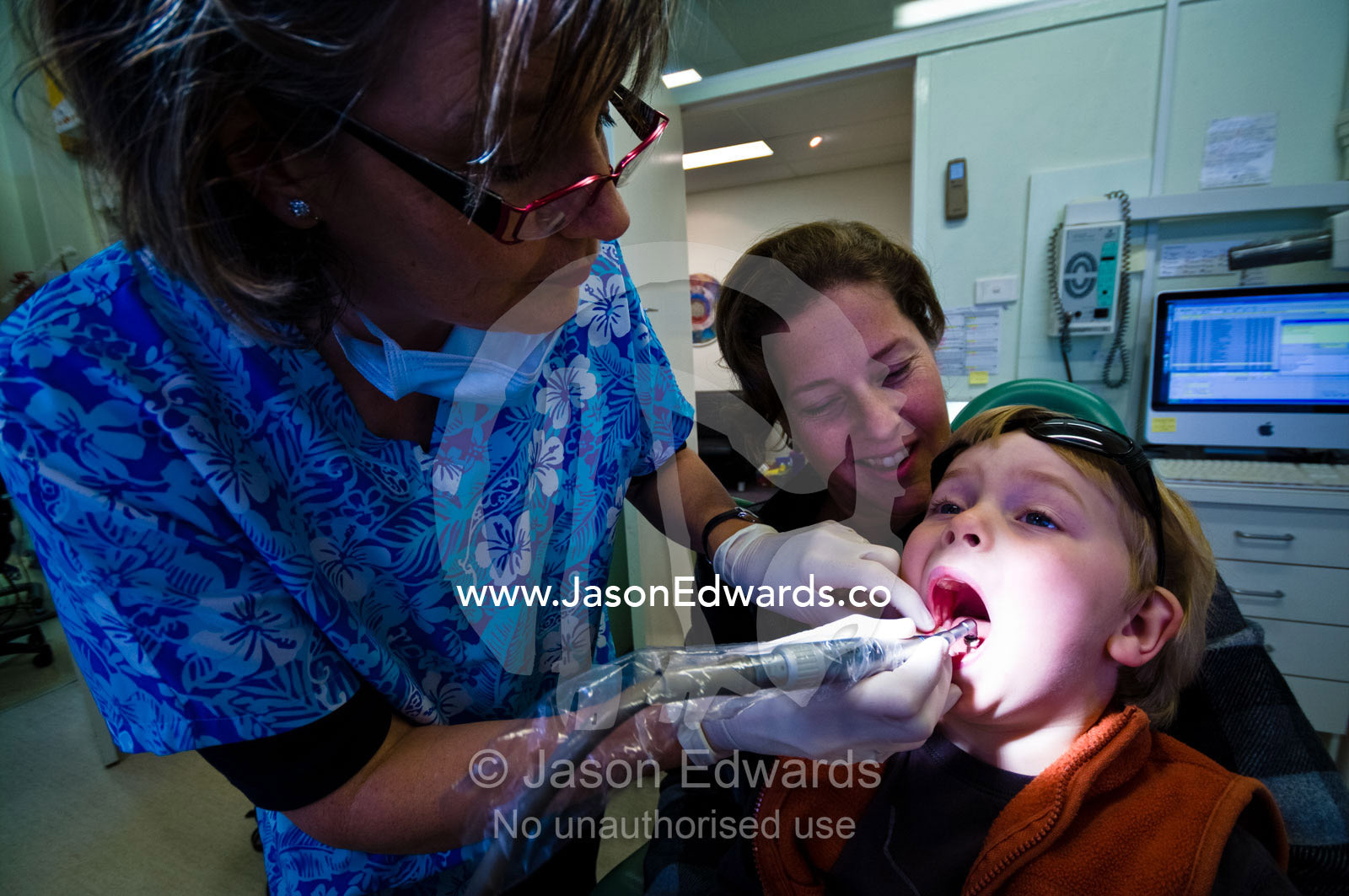 A dentist polishes a boy's teeth at his first check-up. East Melbourne, Melbourne, Victoria, Australia.