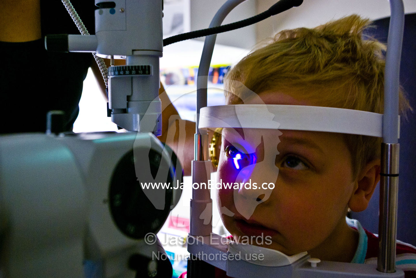 A children's optometrist gives a small boy his first eye examination. Hawthorn, Melbourne, Victoria, Australia.