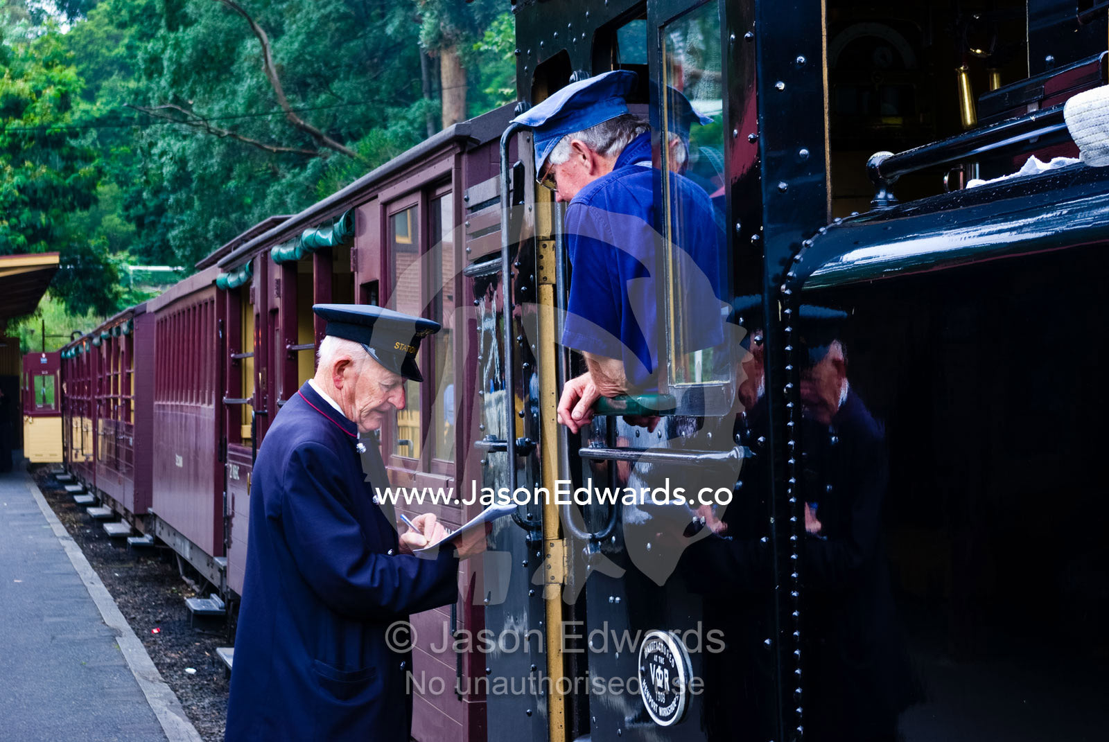 The station master confirms timetables with a steam train driver. Belgrave, Melbourne, Victoria, Australia.