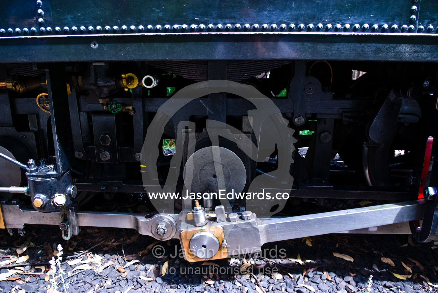 Coupling rods connect the drive wheels together on a steam train. Lakeside, Emerald, Melbourne, Victoria, Australia.