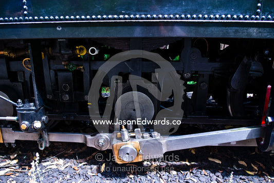 Coupling rods connect the drive wheels together on a steam train. Lakeside, Emerald, Melbourne, Victoria, Australia.