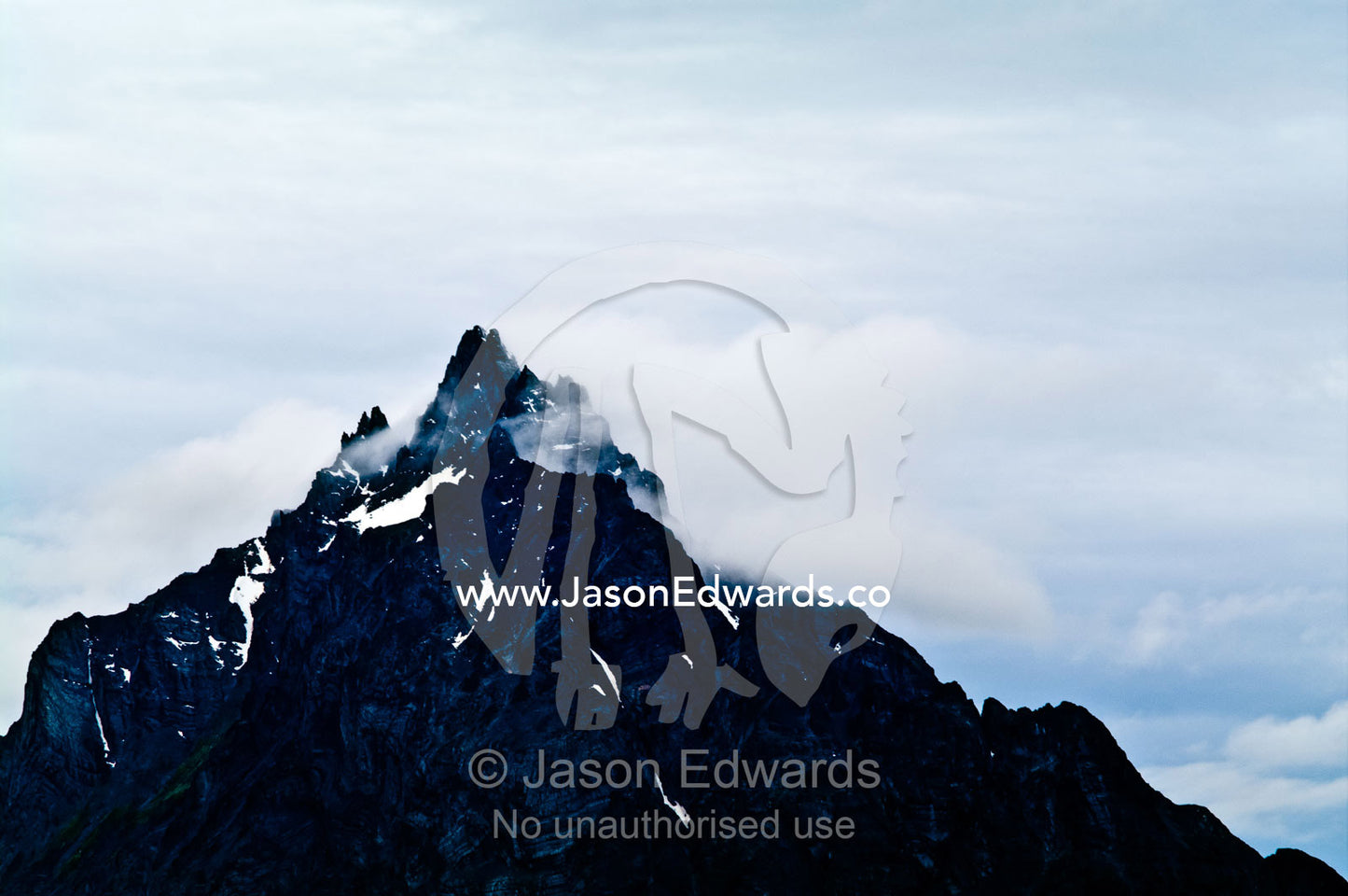 Storm clouds gather around the jagged summit of an Andes mountain. Mount Olivia, Martial Mountains, Fuegian Andes, Ushuaia Bay, The Beagle Channel, Tierra del Fuego Archipelago, Straits of Magellan, Ushuaia, Tierra del Fuego Province, Patagonia, Argentina.