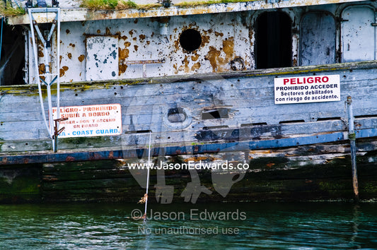 Warning signs ban climbing on a tugboat shipwreck for safety hazards. Ushuaia, The Beagle Channel, Ushuaia Bay, Tierra del Fuego Archipelago, Straits of Magellan, Tierra del Fuego Province, Patagonia, Argentina.