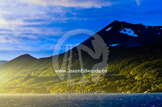 Sun rays illuminate a beech forest on lower slopes of the Andes. Ushuaia, Martial Mountains, Fuegian Andes, Ushuaia Bay, The Beagle Channel, Tierra del Fuego Archipelago, Straits of Magellan, Tierra del Fuego Province, Patagonia, Argentina.