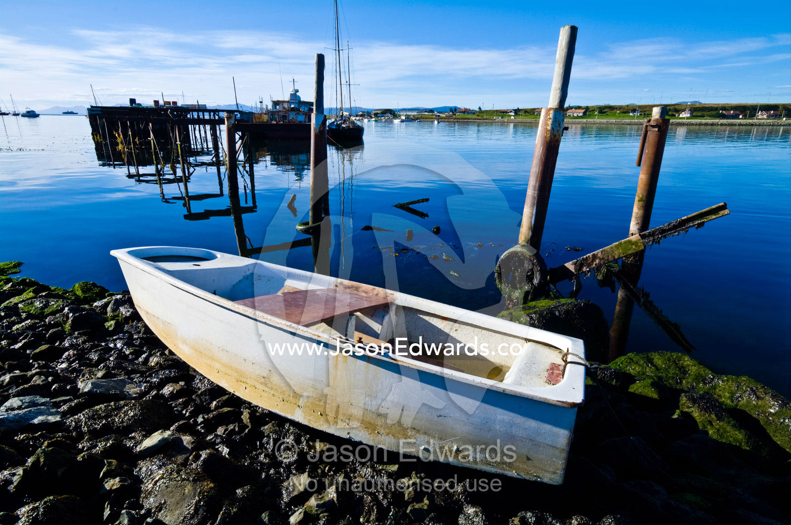 A small paddle boat beached on the rocky shore of a fishing village. The Beagle Channel, Tierra del Fuego Archipelago, Strait of Magellan, Tierra del Fuego Province, Patagonia, Argentina.