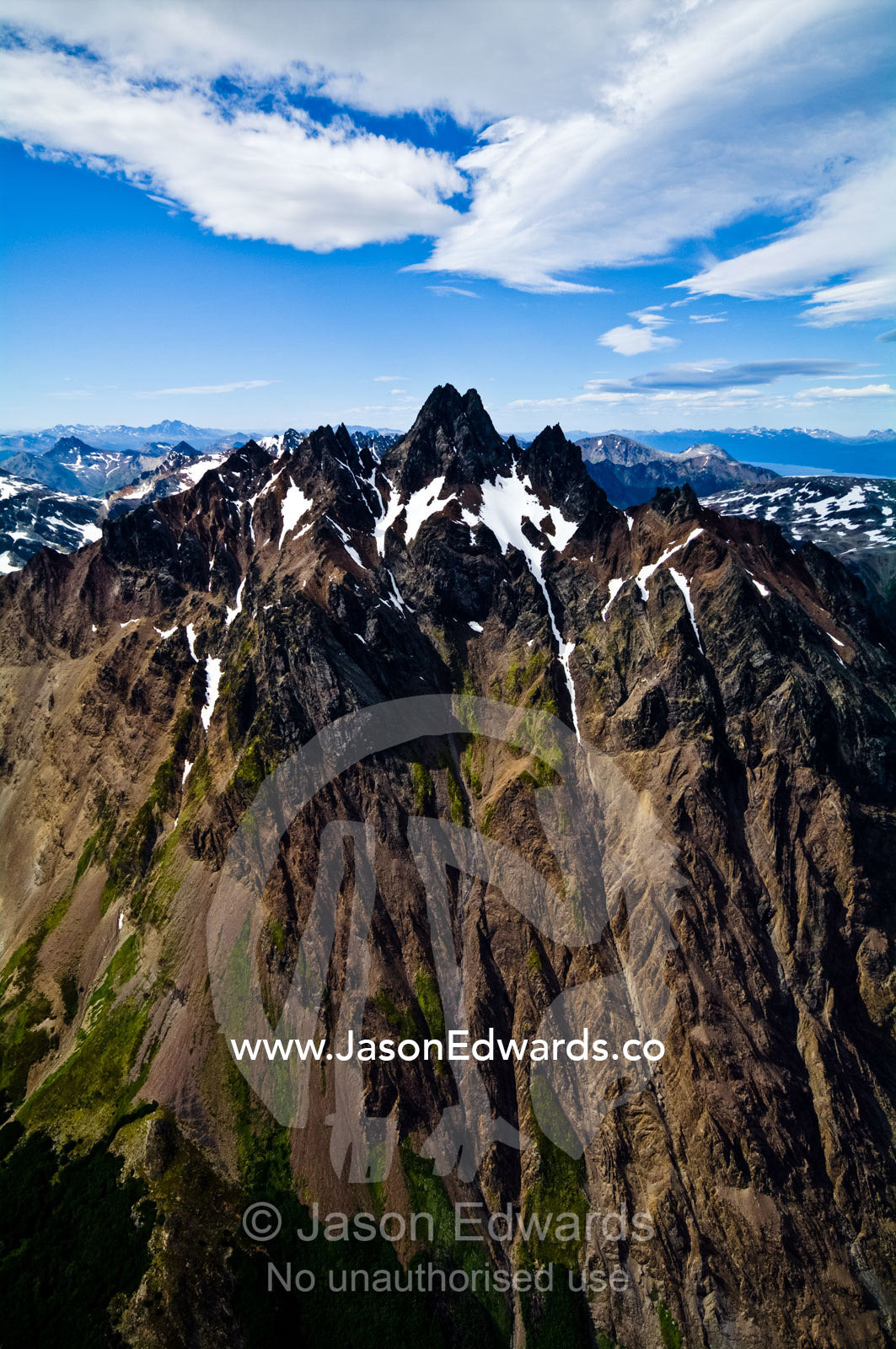 The jagged peak of a mountain erupts from the Andes Mountain range. Glacier El Martial, Ushuaia, Fuegian Andes, Tierra del Fuego Archipelago, Strait of Magellan, Tierra del Fuego Province, Patagonia, Argentina.