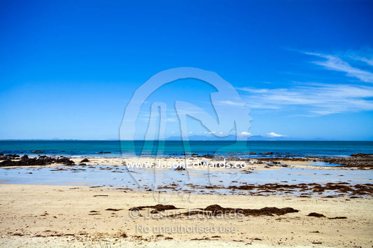 Rock pools scattered along a beach exposed by the low tide. Walkerville, Bass Strait, South Gippsland, Victoria, Australia.