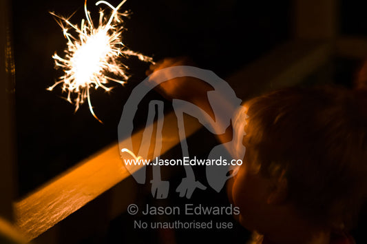 A small boy plays with a party sparkler at New Years eve night. Venus Bay, Cape Liptrap Coastal Park, Bass Strait, South Gippsland, Victoria, Australia.