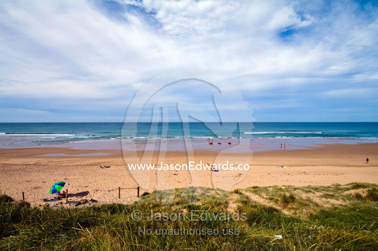 A lone beach umbrella on a wide beach in summer. Venus Bay, Cape Liptrap Coastal Park, Bass Strait, South Gippsland, Victoria, Australia.